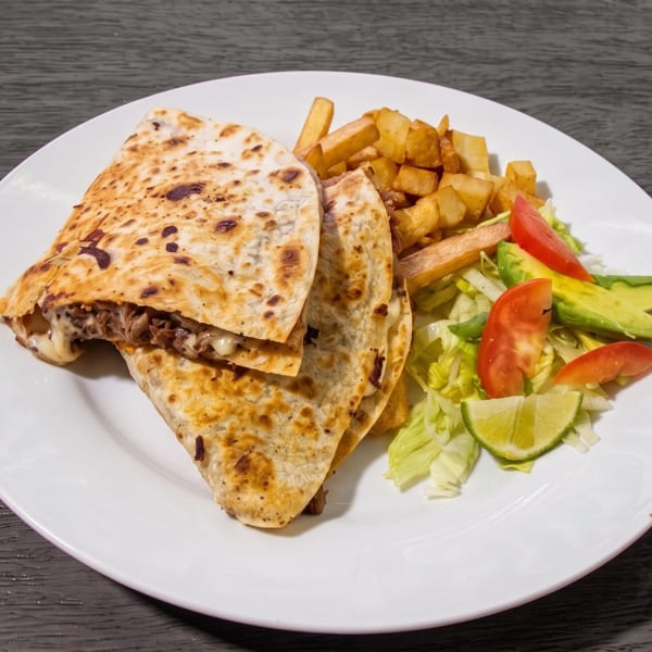 Two quesadillas with melted cheese and meat, served with fries and a side salad.